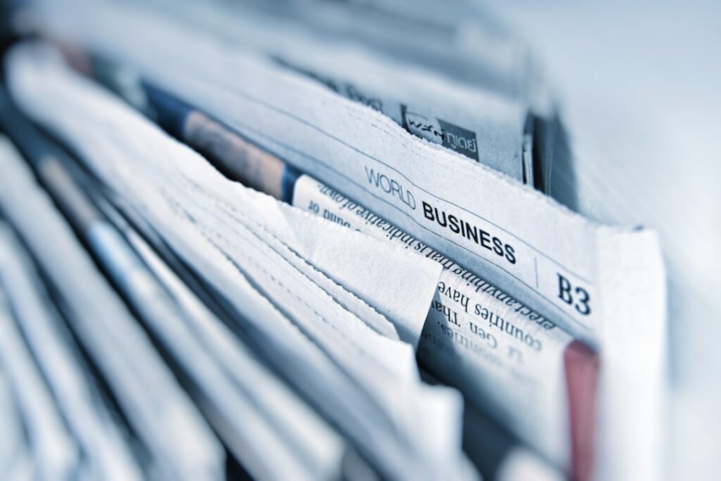 Business newspaper pages spread out on a desk